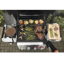 Gril à gaz avec des aliments grillés tels que steak, légumes et poivrons farcis.