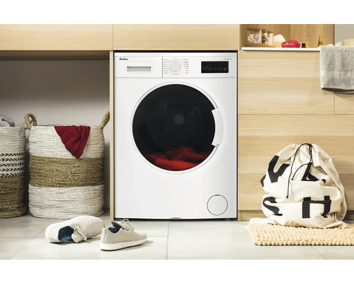 Amica Waschmaschine in einem hellen Waschraum mit Wäschekörben und Wäschesack