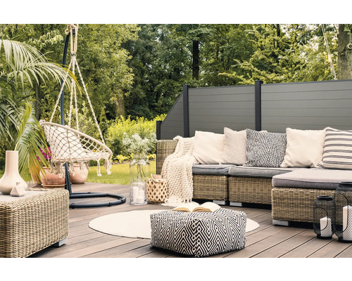 Scène d''une terrasse avec mobilier de salon, fauteuil suspendu et clôture d''intimité