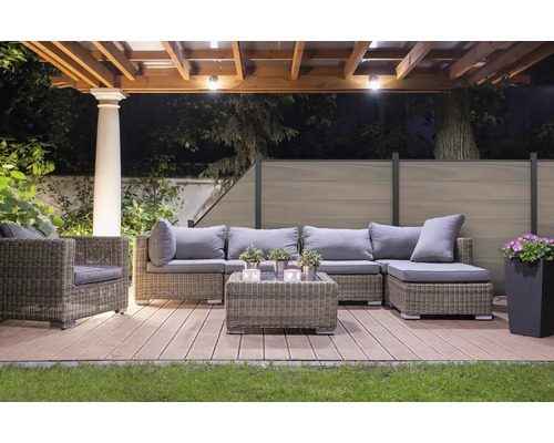 Ensemble de salon de jardin sur une terrasse en bois sous une pergola avec éclairage