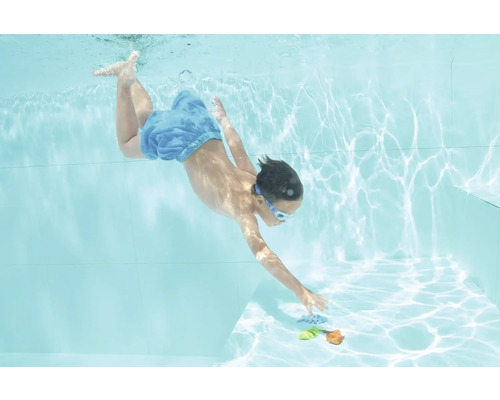 Junge taucht mit Schwimmbrille nach Spielzeug im Schwimmbad