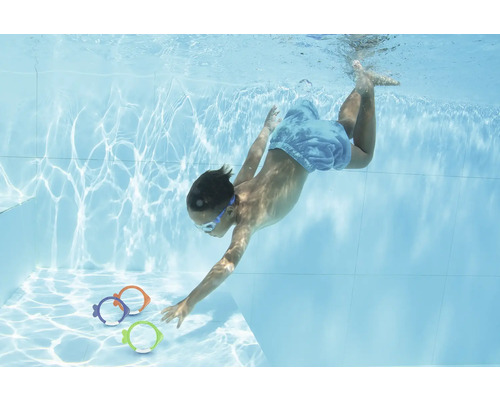 Kind taucht im Schwimmbad nach Spielzeugfischen