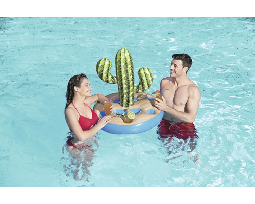 Ein Paar entspannt im Schwimmbad mit einer aufblasbaren Getränkeinsel in Kaktusform.