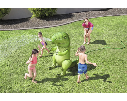 Scène de jardin avec des enfants jouant avec un arroseur d''eau dinosaure gonflable, tandis qu''une femme regarde