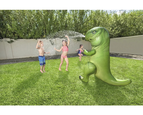 Scène d''extérieur avec des enfants jouant avec un arroseur d''eau dinosaure gonflable