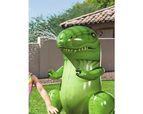Arroseur gonflable dinosaure vert dans le jardin.