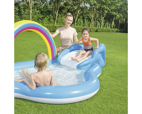Aufblasbares Planschbecken mit Regenbogen und Rutsche im Garten mit Familie