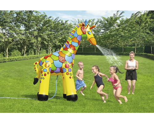 Aufblasbare Giraffe als Wassersprinkler im Garten mit spielenden Kindern.