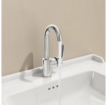 Robinet chromé sur lavabo blanc avec eau courante