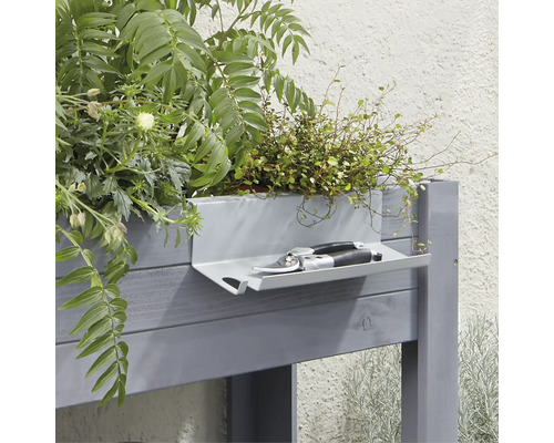 Hochbeet mit Pflanzen und Gartenschere auf Ablage