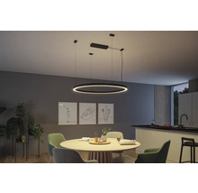 Salle à manger lumineuse avec table à manger ronde, chaises et suspension LED ronde