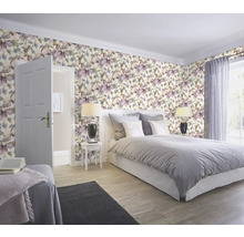 Chambre avec papier peint floral, lit et tables de chevet