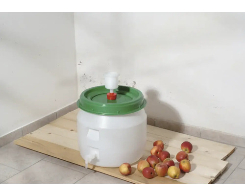 Cuve de fermentation avec barboteur et pommes sur planche en bois