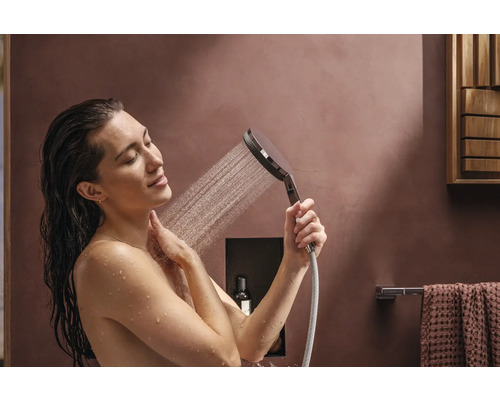 Femme sous la douchette dans la salle de bain