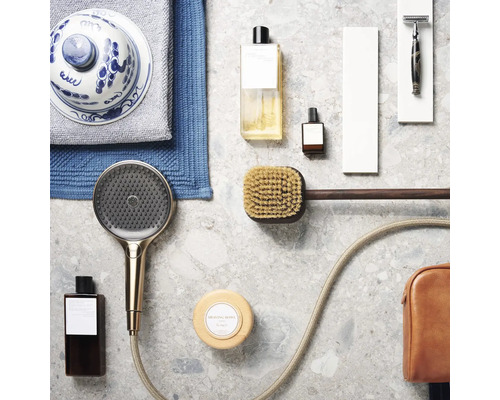 Anordnung von Badartikeln wie Duschkopf, Seife, Bürste und Handtüchern