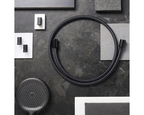 Abbildung eines Brauseschlauchs, einer Handbrause und Wandhaken vor einem dunklen Hintergrund