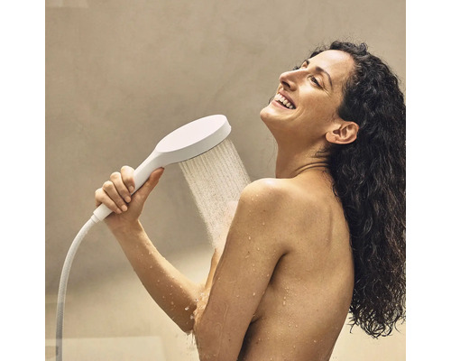 Frau benutzt eine Handbrause beim Duschen