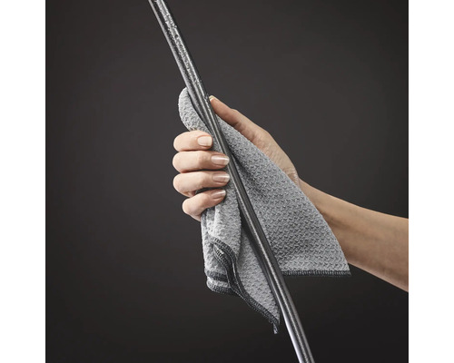 Eine Person reinigt eine Stange mit einem Tuch.