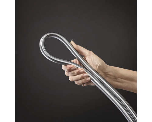 Eine Hand hält ein gebogenes, silberfarbenes Metallrohr.