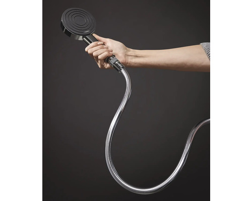 Handbrause mit Schlauch in der Hand gehalten.