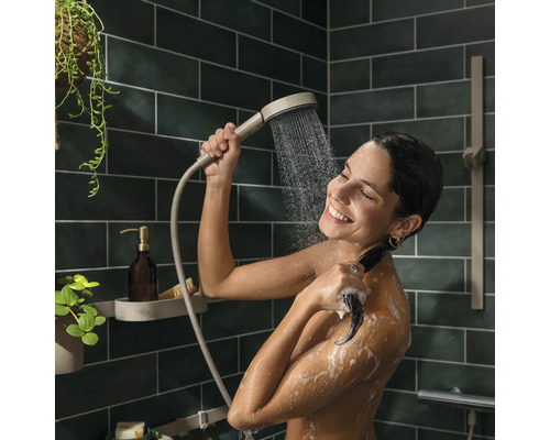 Frau unter der Dusche mit Handbrause in der Hand