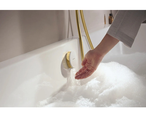 Badezimmer Szene mit Badewanne, Armatur und Hand im Wasser.