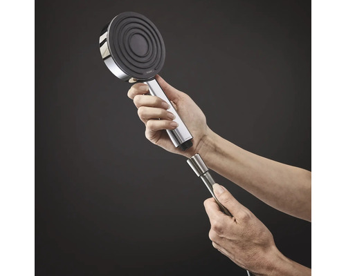 Person montiert Handbrause mit Brauseschlauch