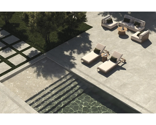 Jardin avec piscine, chaises longues, coin salon et plaques de pierre