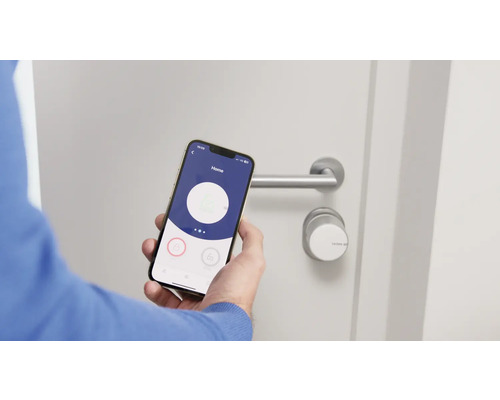 Une personne utilise un smartphone pour actionner une serrure de porte électronique.