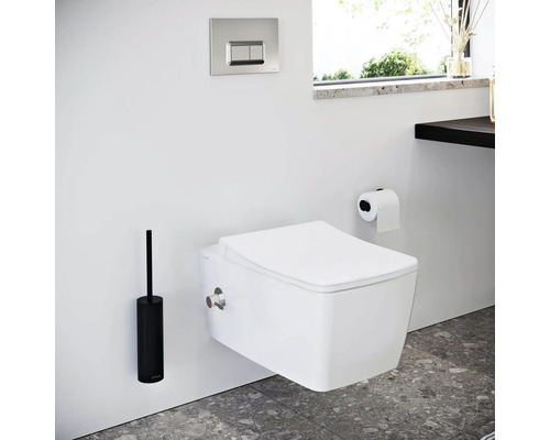 Salle de bains moderne avec WC suspendu, plaque de commande, support papier toilette et brosse WC.