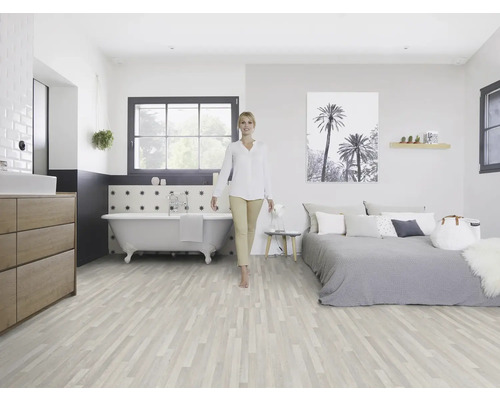 Helles Zimmer mit Holzboden, Badewanne, Bett und einer Frau