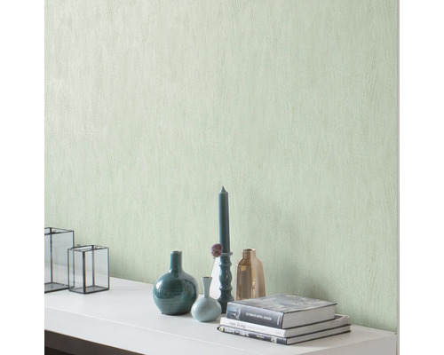 Dekorative Wand mit Strukturtapete und Wohnaccessoires wie Vasen, Kerzen und Büchern