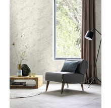 Wohnzimmer mit gemusterter Tapete, Sessel, Tisch, Lampe und Vorhang