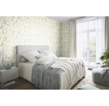 Chambre à coucher avec papier peint à motifs de feuilles, lit et table de chevet