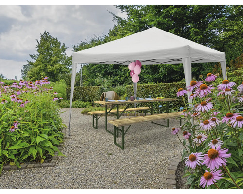 Szene mit einem Pavillon, einer Picknicktischgarnitur und Blumen im Garten