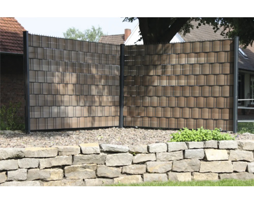 Clôture de protection visuelle avec éléments en plastique et poteaux métalliques dans le jardin