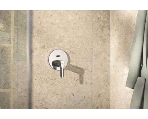 Robinet de douche apparent dans la salle de bains devant le carrelage mural