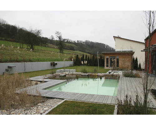 Jardin naturel avec bassin de baignade, terrasse en bois et petite maison de jardin