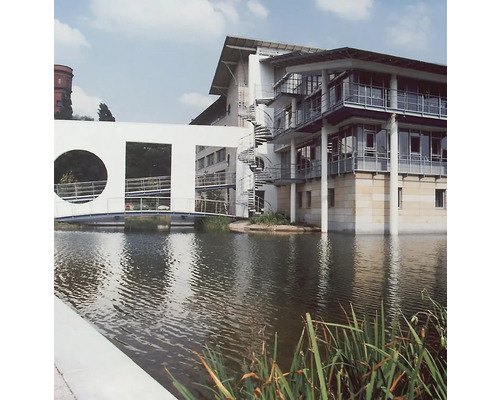 Photographie architecturale d''un bâtiment moderne avec un escalier en spirale et un pont enjambant un fossé