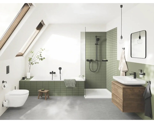 Badezimmer mit Badewanne, Dusche, Waschbecken und Toilette unter einem Dachfenster