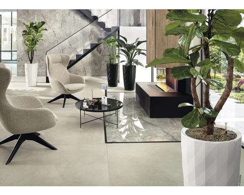 Modernes Interieur mit Sesseln, Tisch, Pflanzen und Kamin.