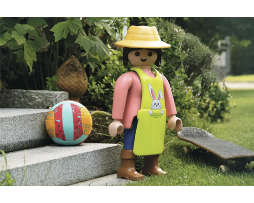 Scène avec figurine Playmobil, ballon et skateboard dans le jardin