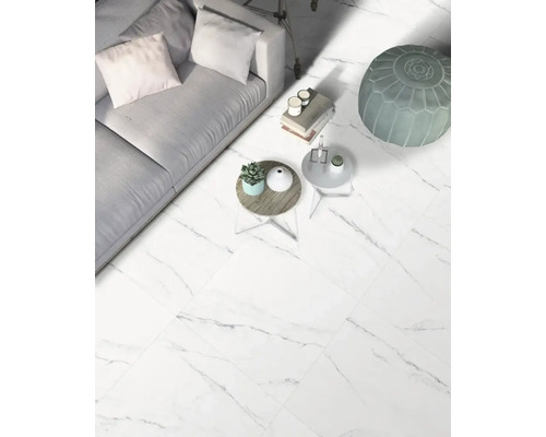 Wohnzimmer mit Sofa, Tischen und Bodenfliesen in Marmoroptik.