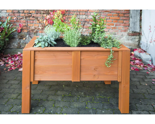 Jardinière sur pieds en bois avec des plantes dans le jardin