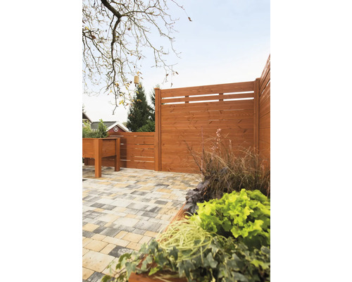 Clôture en bois avec jardinière et sol pavé dans le jardin