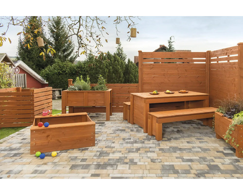 Terrasse en bois avec paravent, potager surélevé, bac à sable, table et bancs