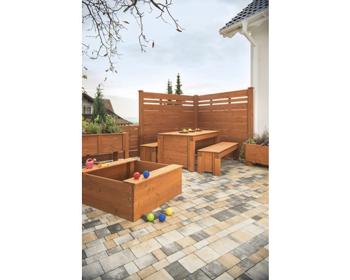 Espace de jardin avec clôture en bois, bac à sable, jardinières et coin salon