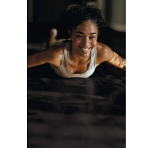 Femme s''entraîne sur un tapis d''entraînement.