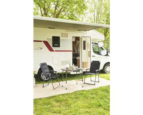 Campingplatzszene mit Wohnwagen, Tisch und Stühlen