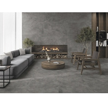 Salon lumineux avec carrelage gris, canapé, fauteuils et cheminée